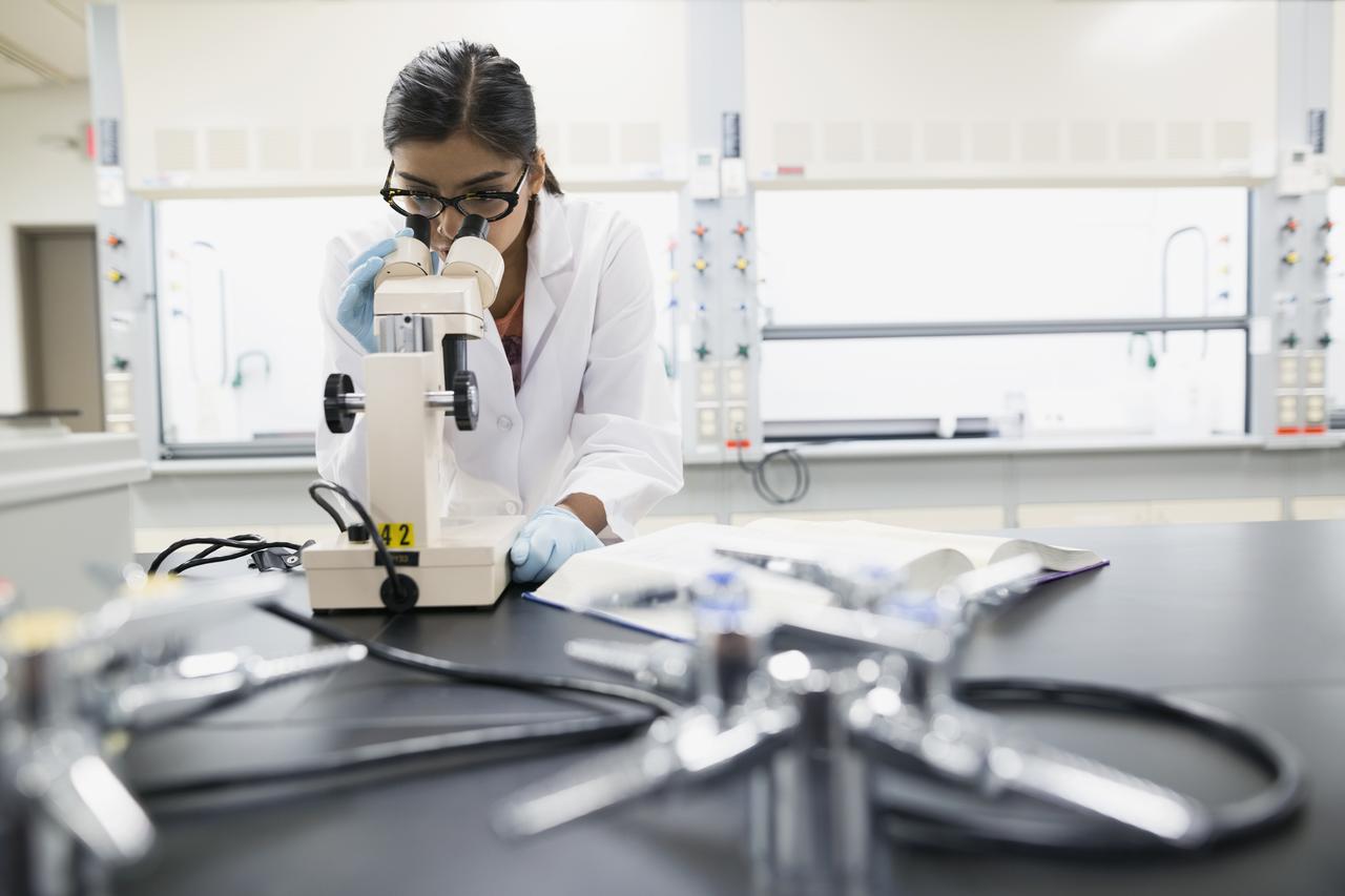 Scientist looking through microscope